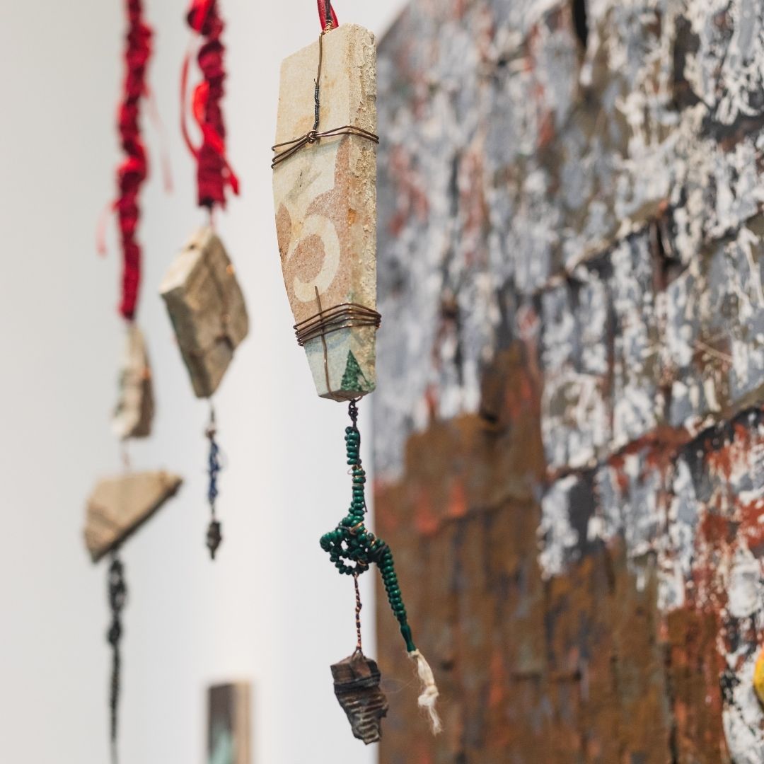 A detail shot of tiles and shrapnel from an artwork.