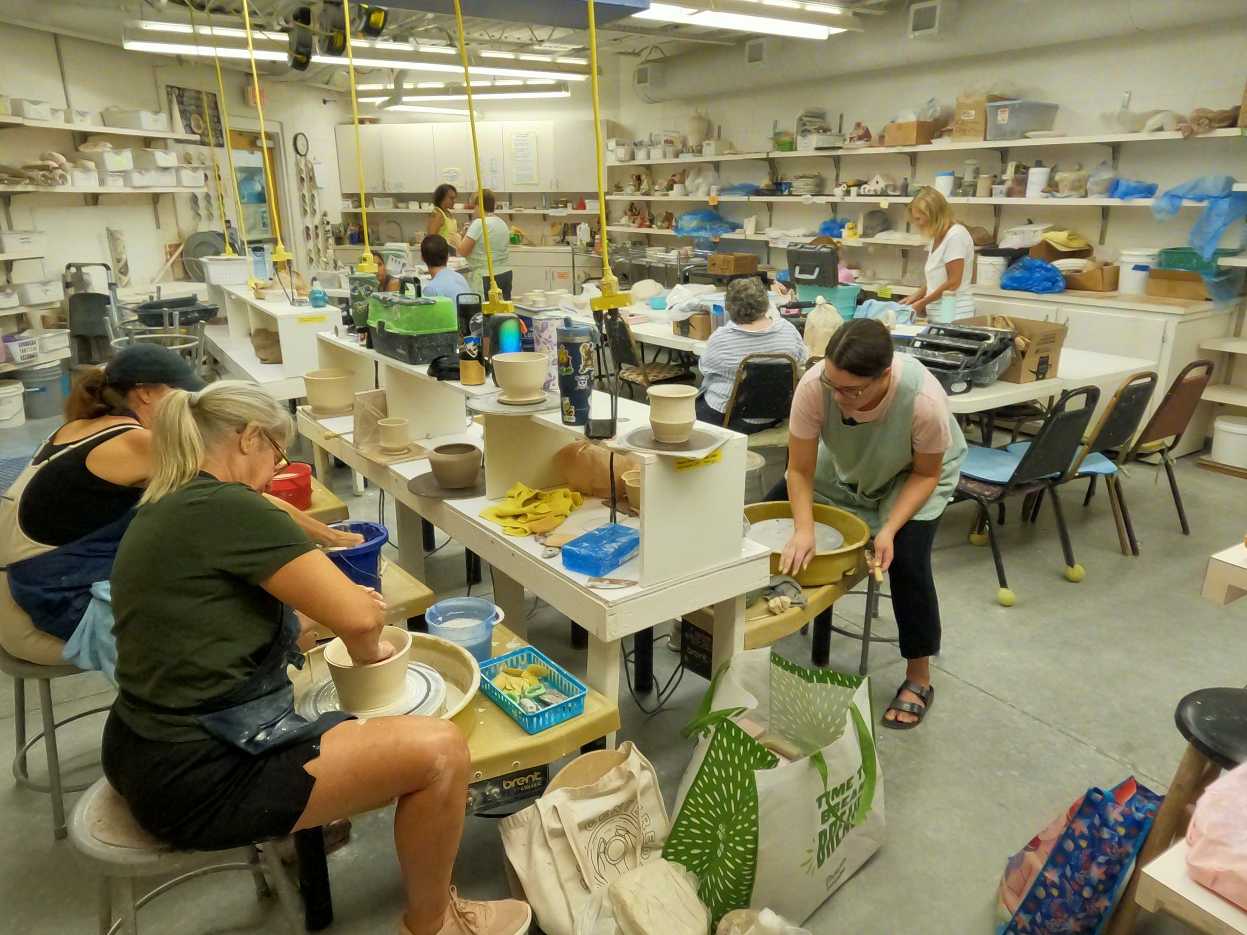 People make art on pottery wheels and tables.