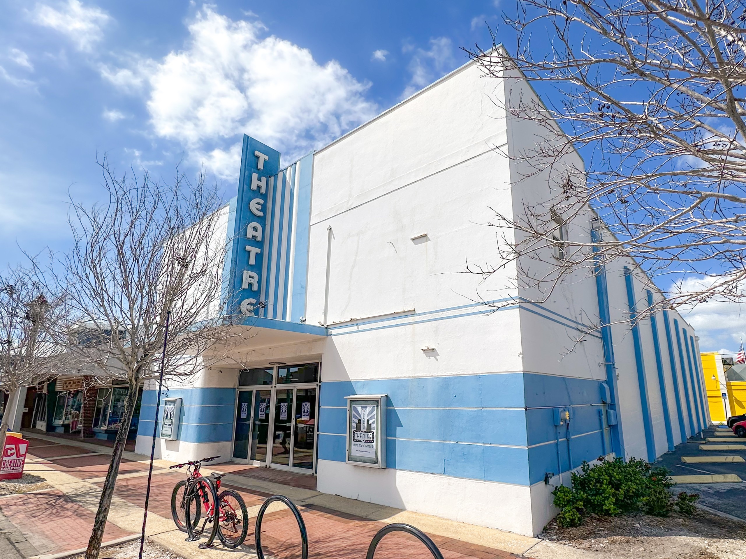 A blue and white building with a sign reading Theatre.