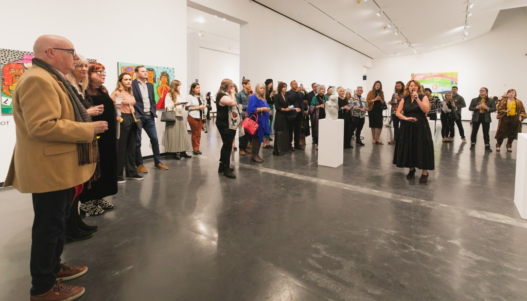 A crowd gathers in a gallery.
