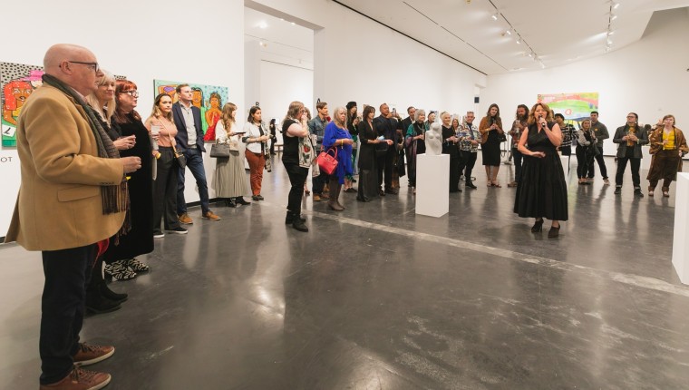 A crowd gathers in a gallery.