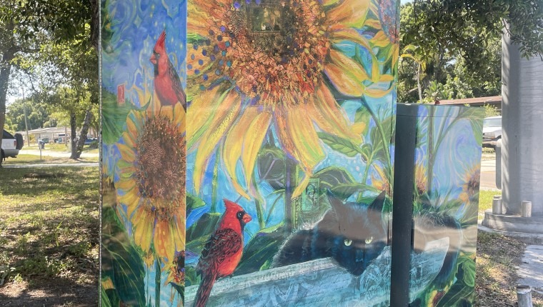 A signal box is decorated with sunflowers.