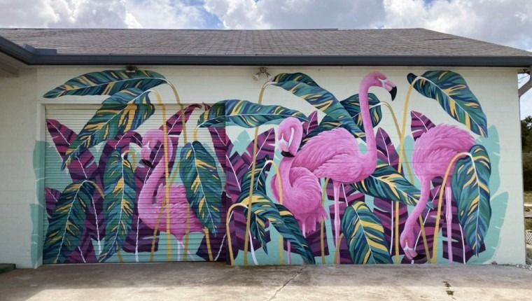 A mural depicts flamingos and tropical plants.