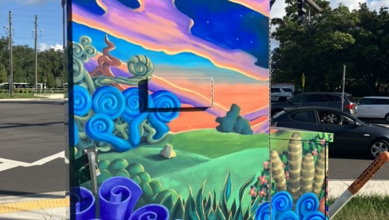 A signal box is decorated with a brightly-colored pattern.