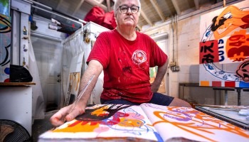 A man poses with artwork.