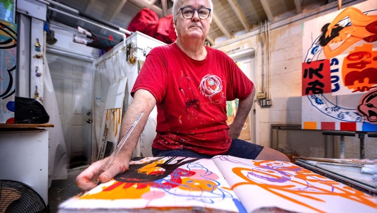 A man poses with artwork.