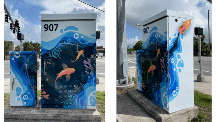 A traffic signal box is decorated with an ocean scene.